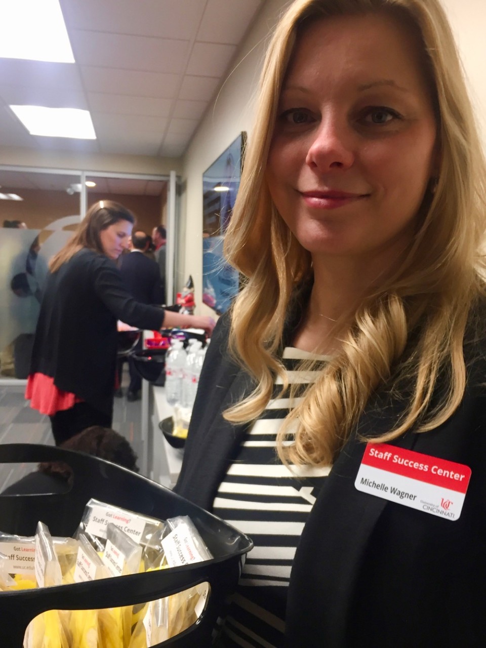 UC Staff Success Center's Michelle Wagner holds a basket of cookies at the ribbon cutting event.