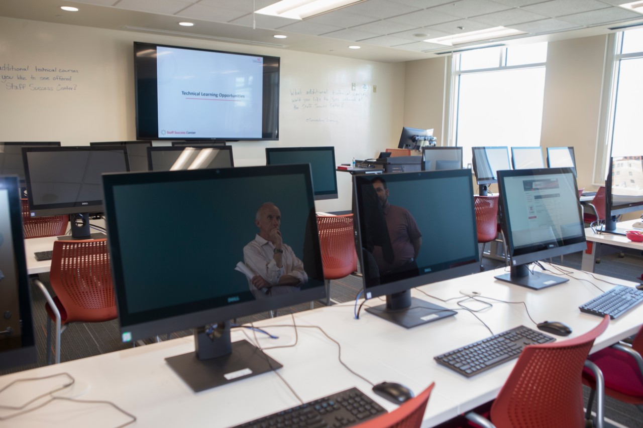 A room of computers line the tables in UC's Staff Success Center.