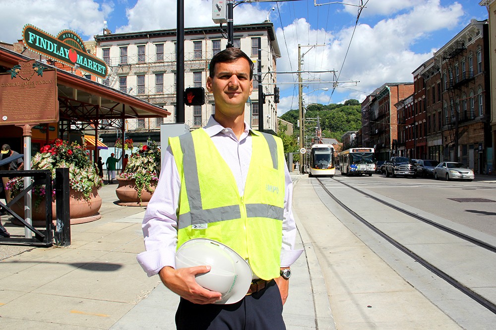 A streetcar begins its route as Mike Prus stands near Findlay Market on Race Street.