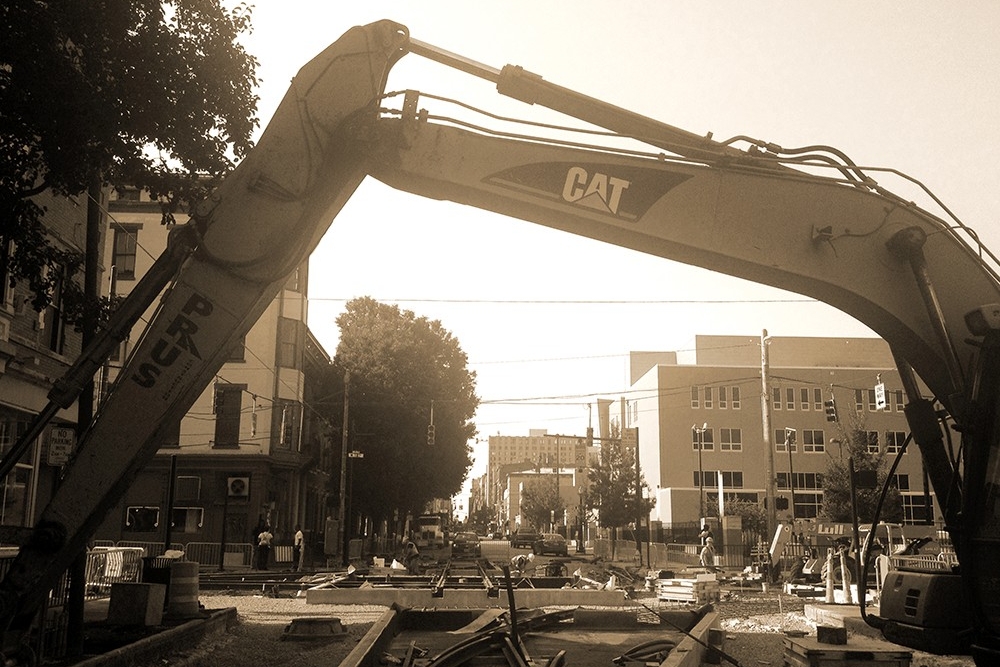 A Prus excavator bridges the trackwork for the diamond at 12th and Race Streets near Washington Park. (July 31, 2014)