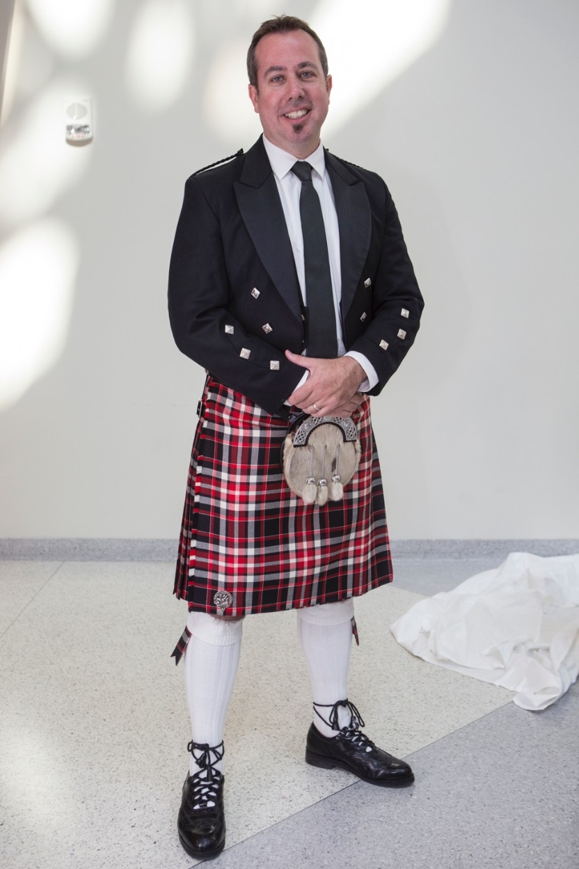 Neil MacKinnon, dean of UC School of Pharmacy stands wearing a UC tartan plaid kilt
