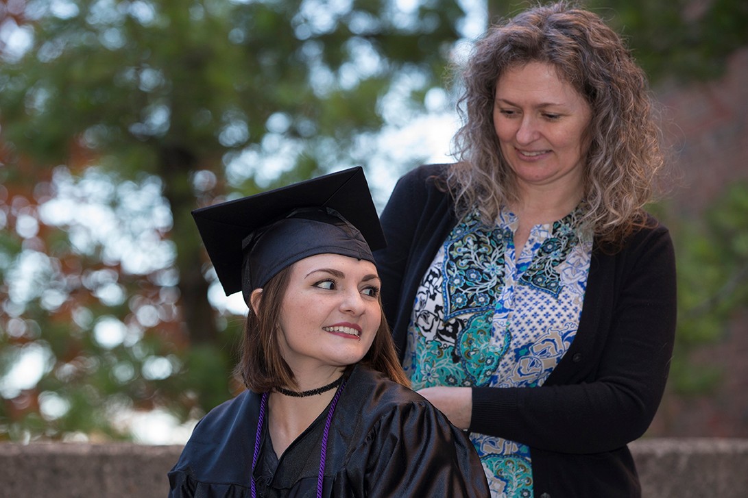 Tori Thomas, in cap and gown, looks back at her mother Melissa Caldwell.