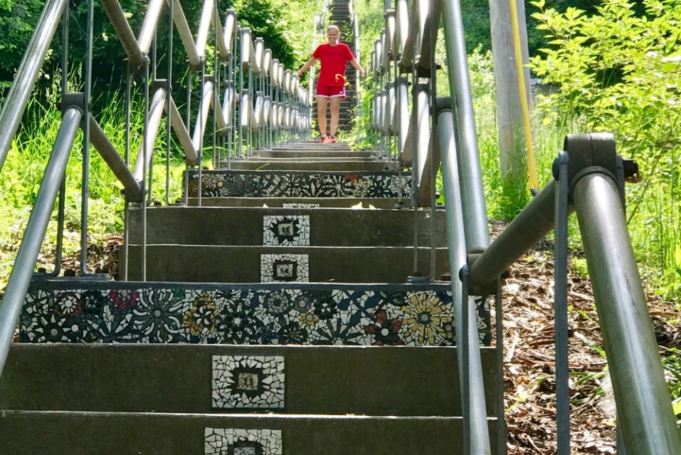 A woman descends the Fairview Park stairs that were decorated by mosaics created by UC Serves volunteers.