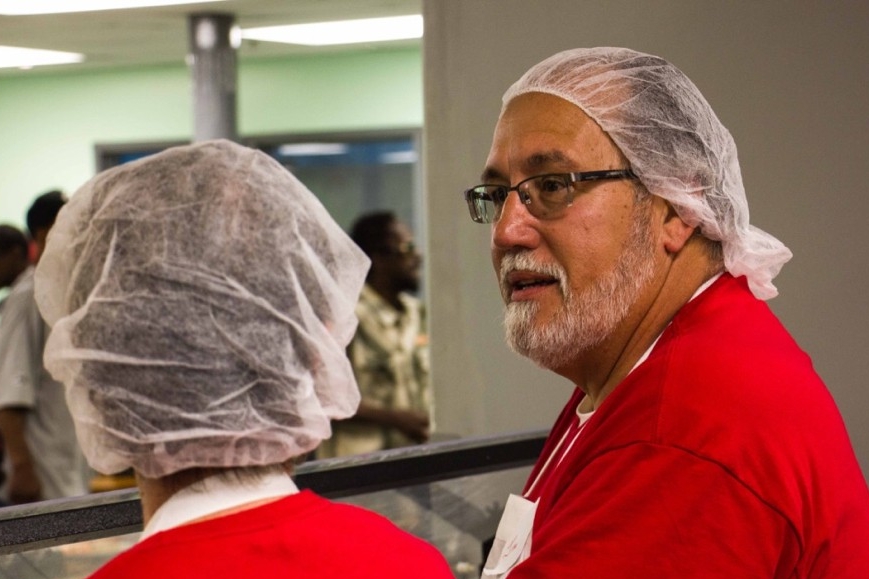 Two UC Serves volunteers wear hair nets as they work at Our Daily Bread Soup Kitchen.