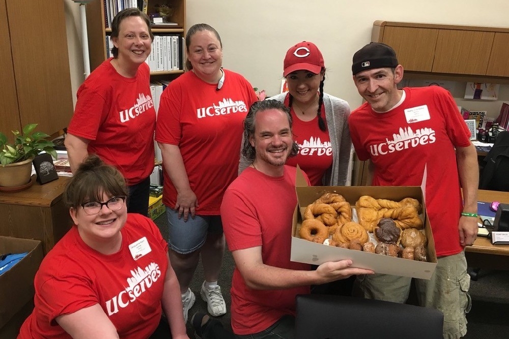UC Serves volunteers hold a box of donuts before their day of work at Cincinnati's Gamble Nippert YMCA.