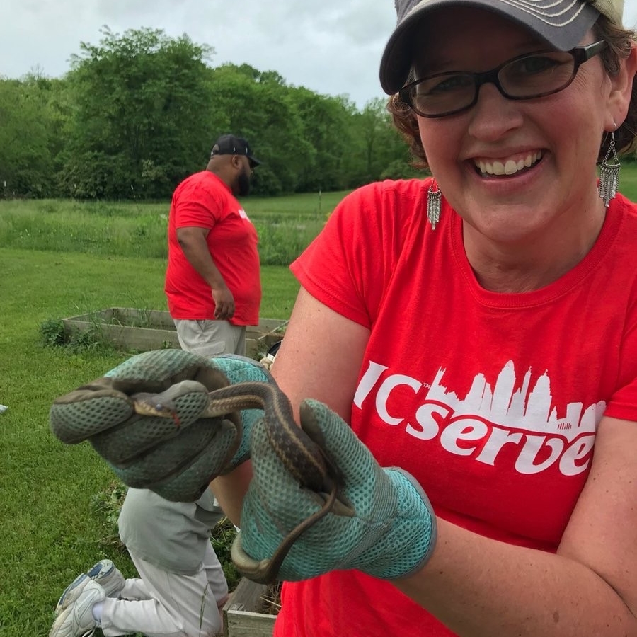 UC Clermont biologist Krista Clark holds a garter snake at the UC Clermont Community Garden.