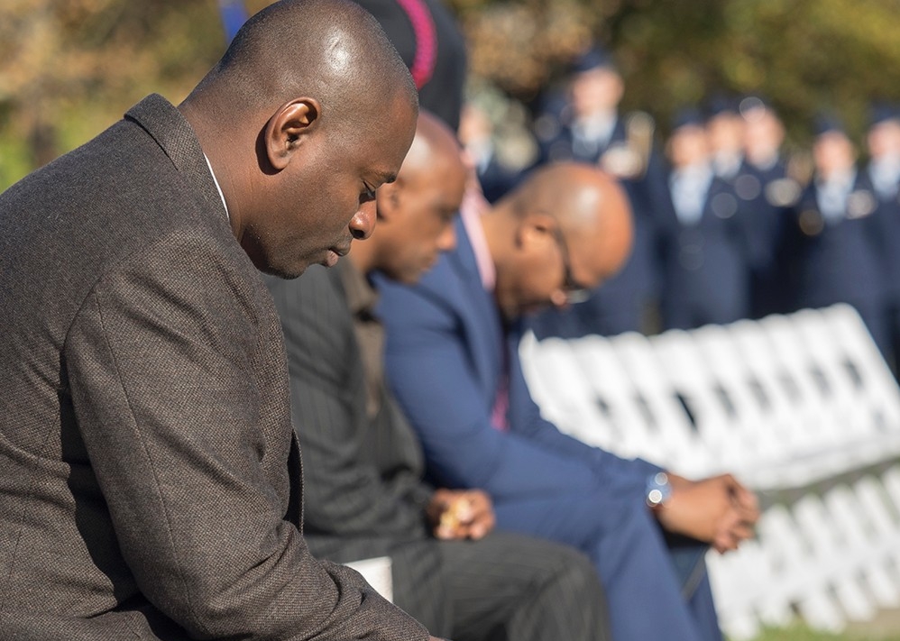 Several attendees of the UC Veterans Day ceremony bow their heads in a moment of silence and prayer.