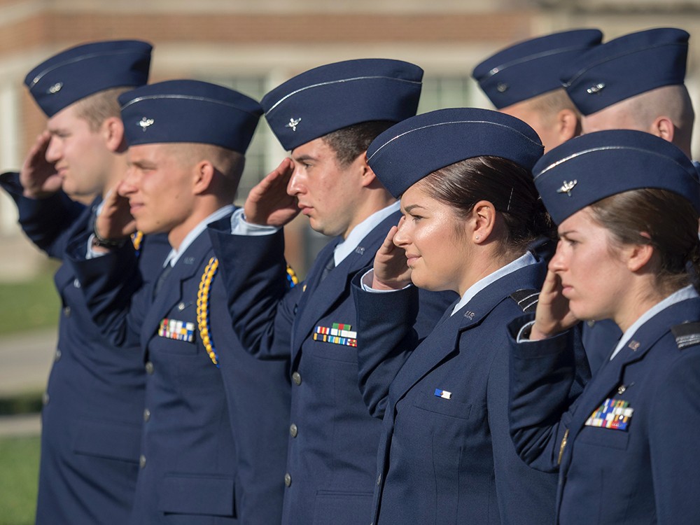 Soldiers stand at attention in salute of veterans.