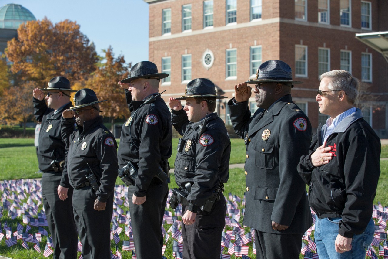 The UC Police Department command staff salutes.