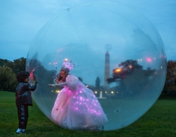 As the sun sets, Glinda the Good Witch tries to communicate with a little tyke on the outside of her bubble.