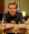 Travis Hagenbuch poses behind his three Emmy Awards.