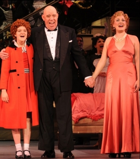 Danette sings on stage with Annie and Daddy Warbucks.