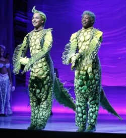 Two men dressed in scaly sea-creature outfits.