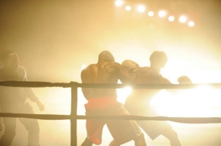 Silhouettes of Rocky fighting another man in the ring.