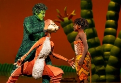 Baldet, face painted green, working the Timmon puppet in "Lion King."
