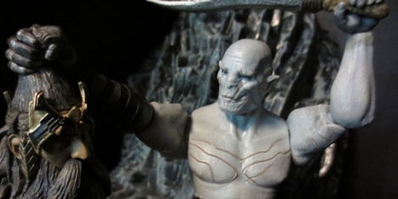 The action figure of Azog holds the severed head of the dwarf King Thror up in victory.