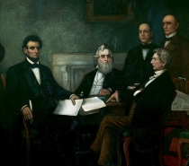 President Lincoln sitting at a table with four men around him.