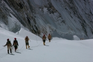 Expedition members roped together to cross a snowy plain on the mountain.