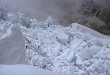 Two dots crossing a bridge in the middle of giant snow and ice formations.