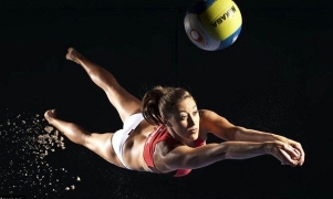 Denise Johns dives to hit a ball (in a studio shot).