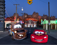 Two cars from the Cars movie sit in the middle of the street in this special section of Disneyland.