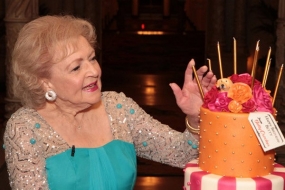 Betty White admires her cake.