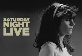 Zooey Deschanel poses for a SNL promo shot in black and white.