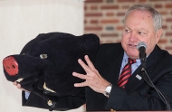 University of Cincinnati alum Tom Humes holds up the head of the mascot costume he wore.
