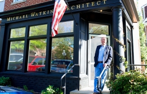 University of Cincinnati alum and an architect, Mike Watkins, stands in front of his storefront office.