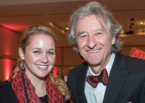 A photo of a smiling young woman, Olivia Hiles, who is a University of Cincinnati student and the winner of a design contest. She is pictured with a University of Cincinnati dean, Robert Probst.