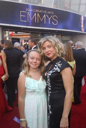 Alumna Cara Sullivan and her look-alike 11-year-old daughter Rachel stand in front of the Emmy Awards sign.