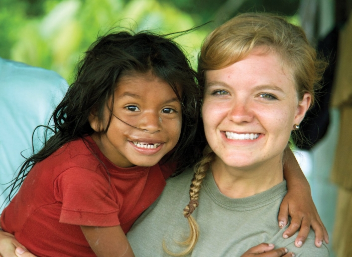 UC student Natalie Bullock gets a big hug from a girl from Warao while on her international travels.