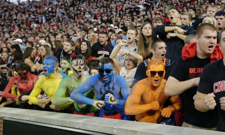 A crowd of University of Cincinnati fans, painted in all colors of the rainbow, put everything they've got into a cheer for the home team.