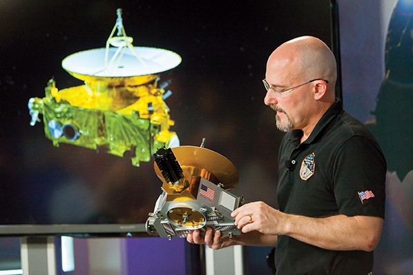 Chris Hersman holds model of New Horizons