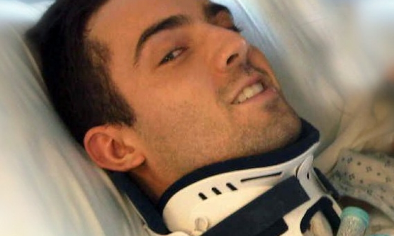 Ryan Atkins in a neck brace in the hospital