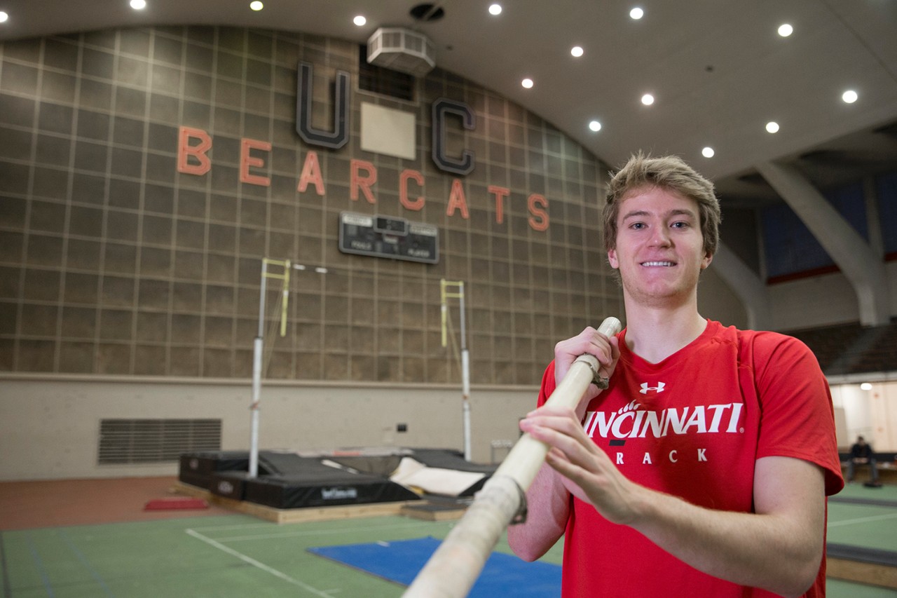 Adrian Valles holds pole vault inside UC's Armory Fieldhouse