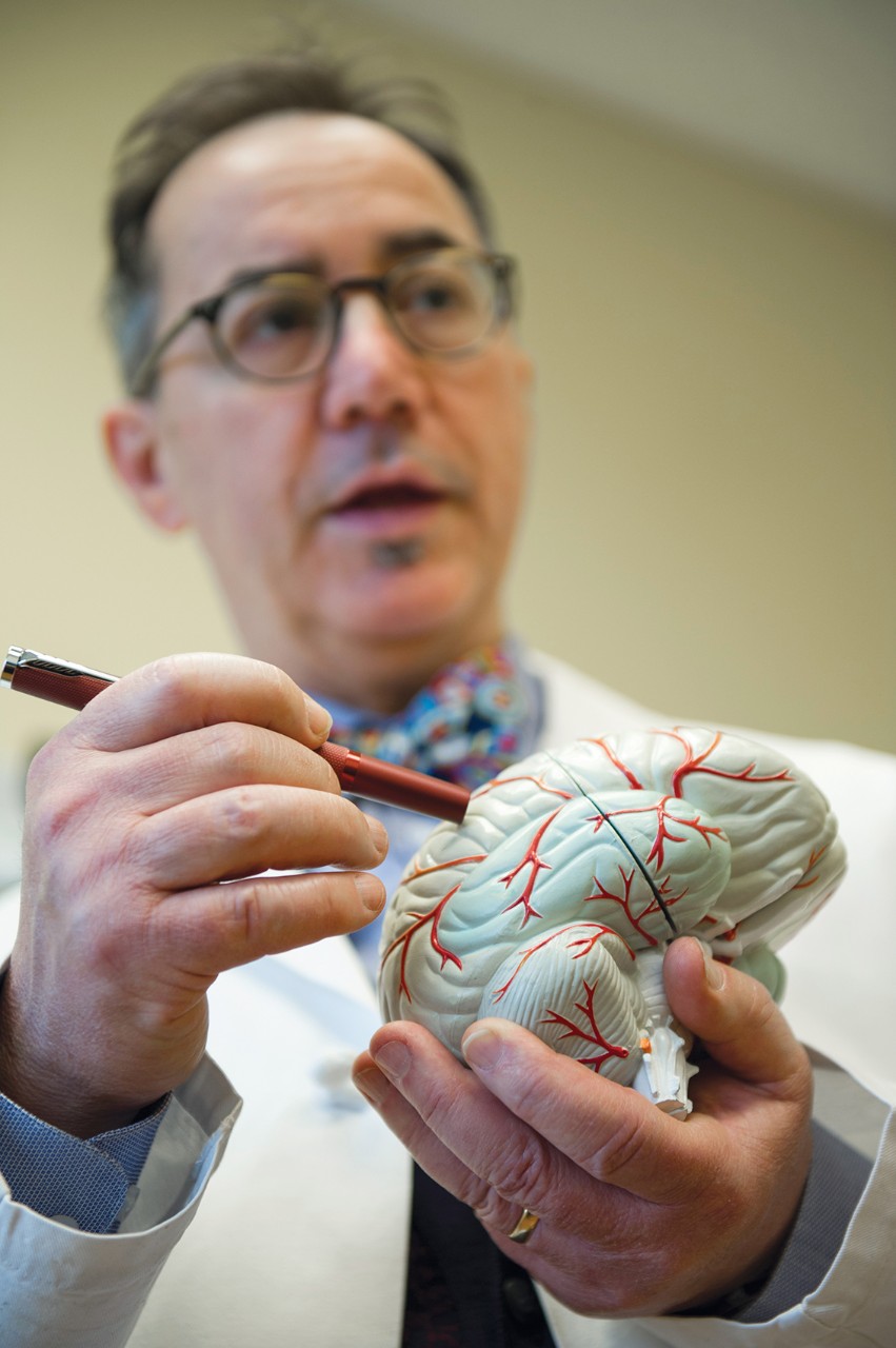 Dr. Privitera holding a model of a human brain.