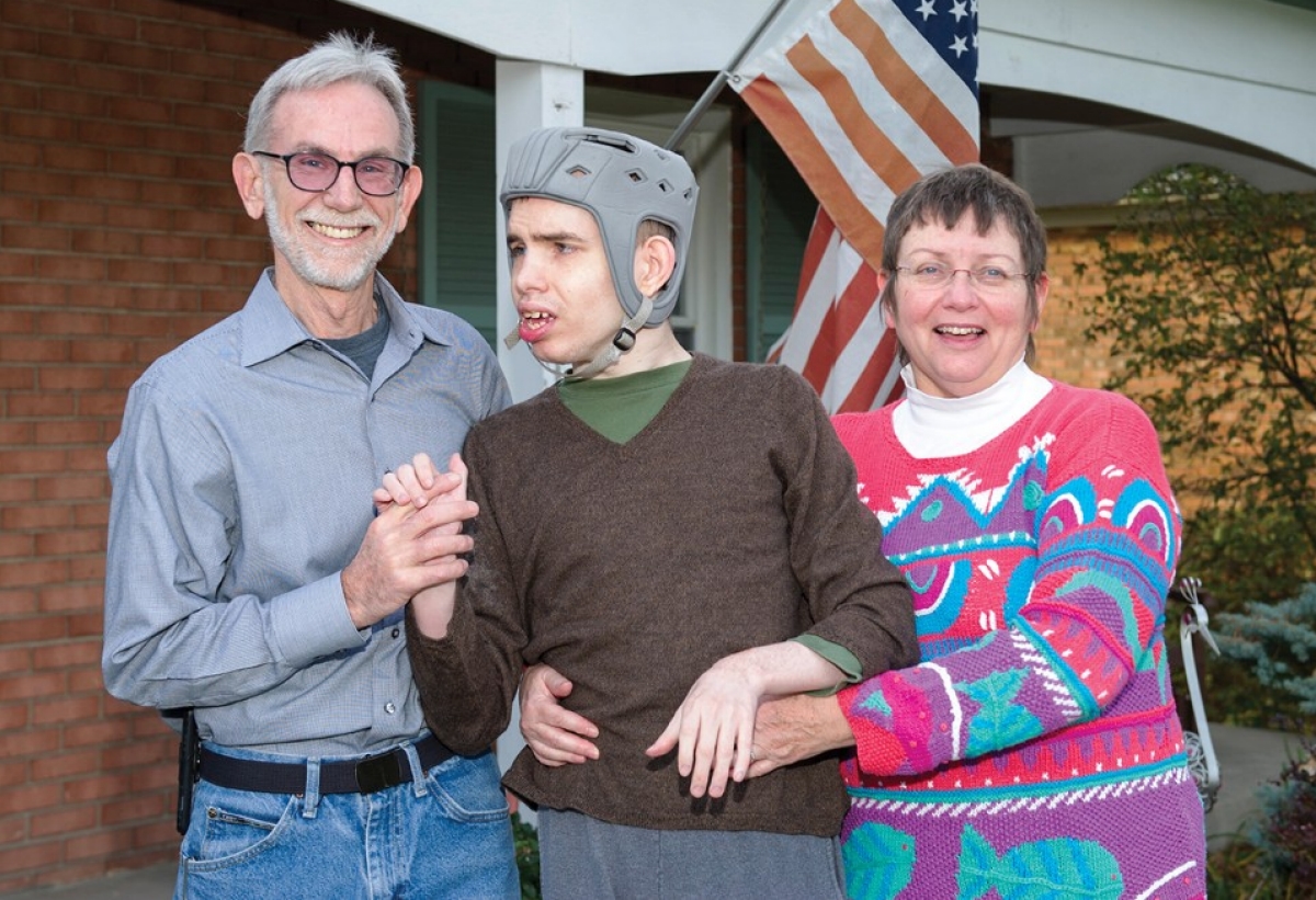 The Plott family embraces outside their home.