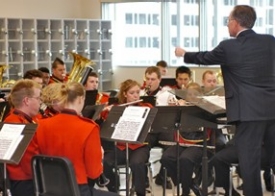 Terren Frenz directs the UC Bearcat Band at the dedication of the group's first official band room. Along the back wall are secure cages for instruments. The window faces Gettler Stadium 