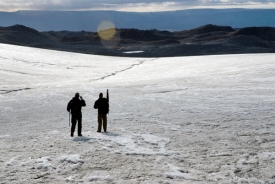 Researcher Scott Travis, left, and Colby Smith, geology graduate student, hike down the Istorvet Ice Cap in Greenland, one of many exotic locations where Lowell and his team study glacial patterns and their relation to climate change.