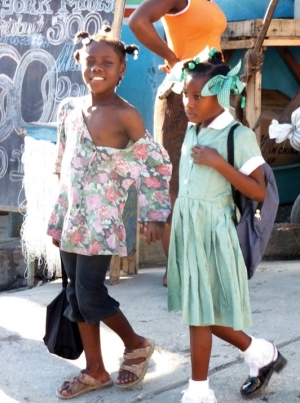 In Haiti, a restavek child (on the left) walks to school, but never enters the doors. She is simply escorting the uniformed girl to school as part of her domestic duties. She smiles at Jean-Robert Cadet, who was speaking to her and encouraging her to ask her "host family" about going to school, too. 