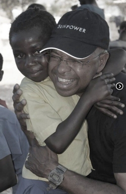 Cadet hugging a restavek in Haiti, where he returns regularly.