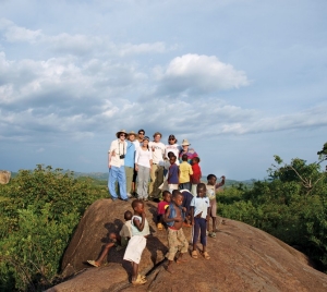 Engineering students can co-op overseas, but they also travel abroad for service trips through   Engineers Without Borders, such as this group in Tanzania, where they were working on a large-  scale water project. Here, they climb a hillside on their day off with children from the village   of Shirati, where they slept in the evenings. The students were working with the Village Life   Outreach Project. photo/courtesy of UC Engineering Without Borders