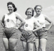 Three young women dressed in uniform shorts and tank tops for exercise.