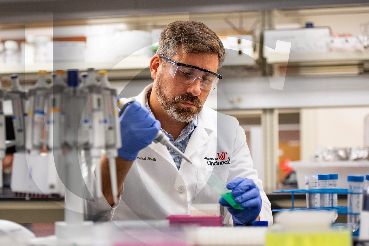 Principal investigator Scott Langevin fills a vile in a research lab