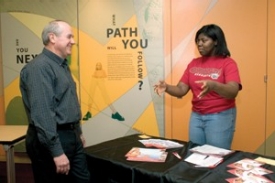 Tom Vick, DAAP '69, of Chicago, engages with UC sophomore and Office of Admissions student ambassador Jennifer Moore in college-fair role-playing at a recent UCART training session. "We tell the students, 'Come and see the campus. You'll be surprised," Vick says.