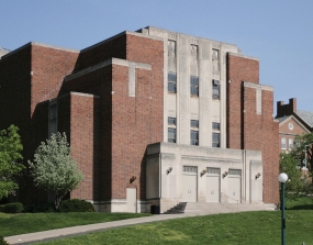 Wilson Auditorium stands with a bright blue sky above it.