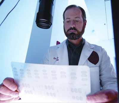 UC researcher Kim Seroogy examines results in his lab.