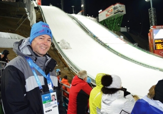 Grant Schaffner stands in front of a competition sledding track at the Sochi Olympics