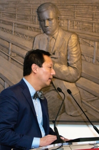 UC President Santa Ono at the podium in front of a bronze bas relief of Neil Armstrong to be installed permanently at the University of Cincinnati.